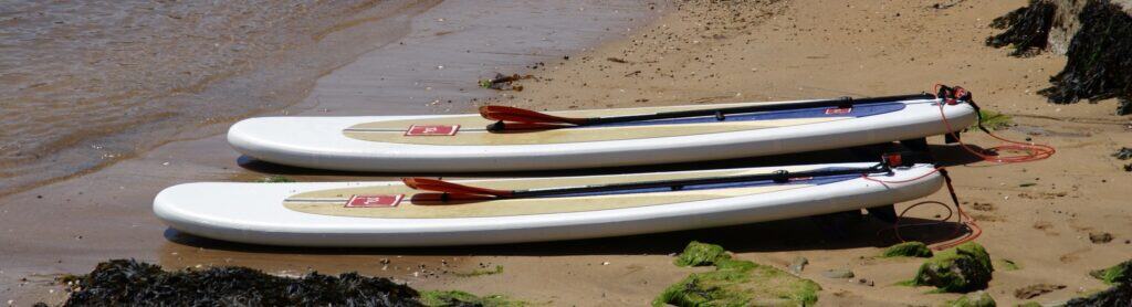 Planche de paddle Opiti sur la plage pour la pratique sportive et loisir aquatique.