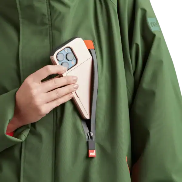 Prise d'écran avec smartphone dans la poche d'une veste outdoor verte, idéale pour sports et activités extérieures.