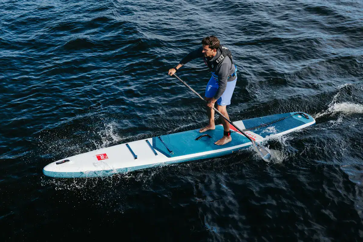 Vue aérienne d'une paddleuse avec pagaie Red Paddle Co sur lac de montagne