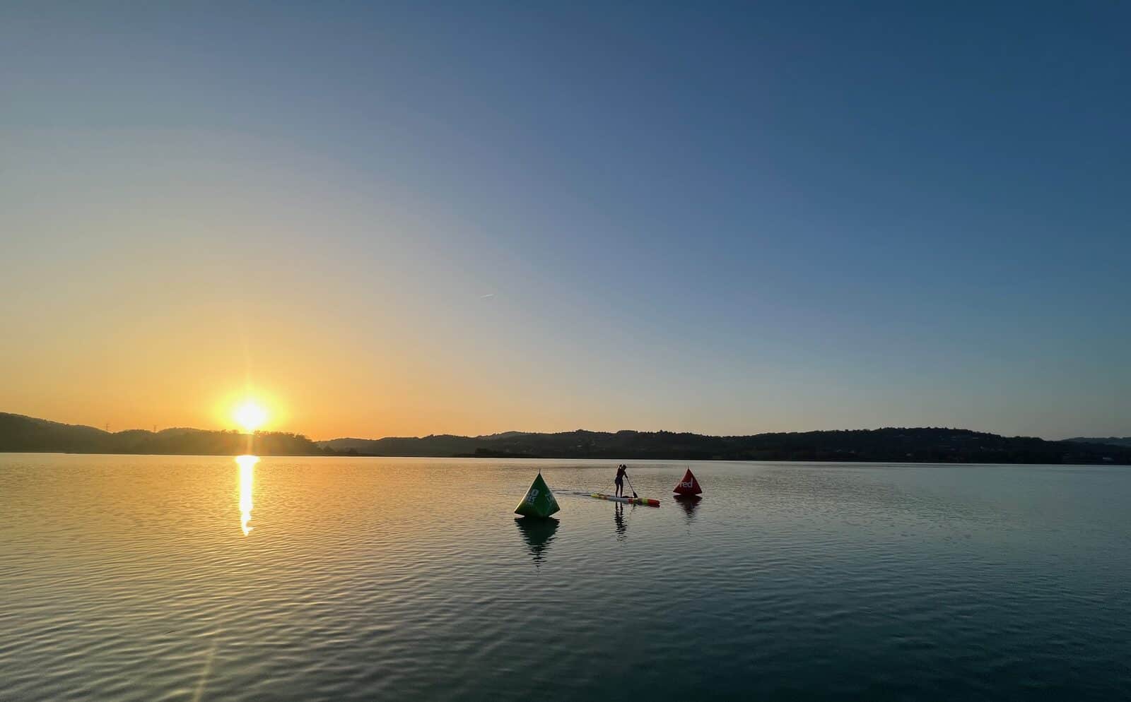 Pagayeur seul en silhouette sur une eau miroir au coucher de soleil, lac d'Annecy